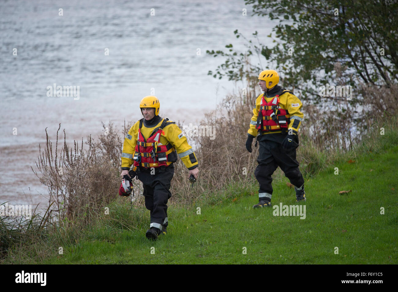 Rescue workers walk along he banks of the River Taff in Cardiff, South Wales, after reports of a body in the water. Stock Photo