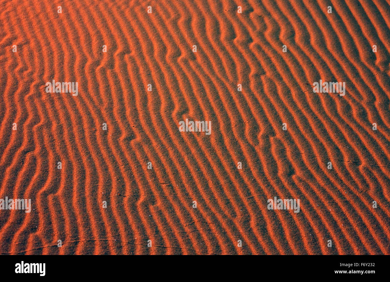 Red formalistic diagonal patterns formed by winds at sunset in the sand dunes of Gomati area, Katalako village, Limnos, Greece Stock Photo