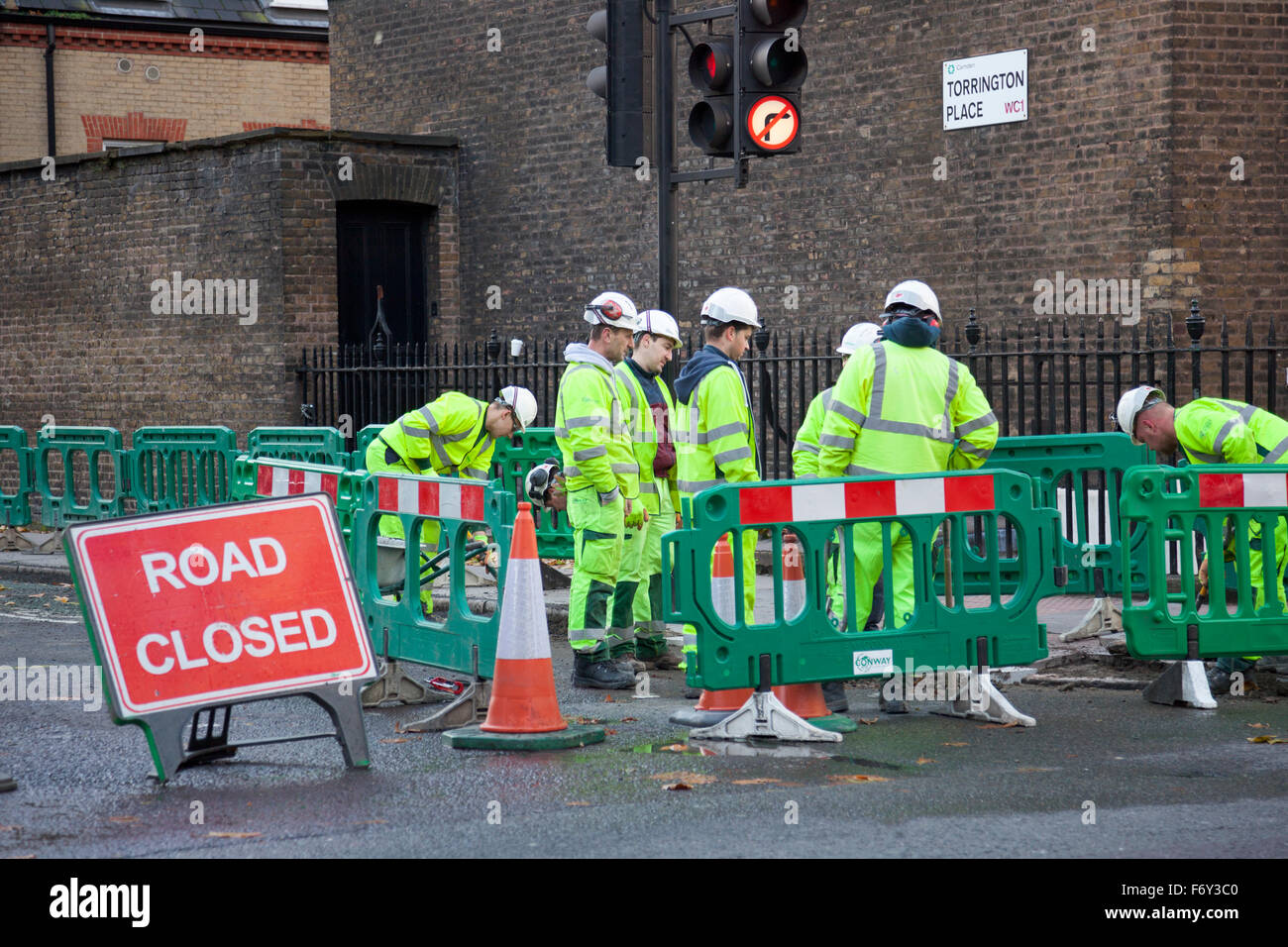 Roadworkers digging up the road Stock Photo