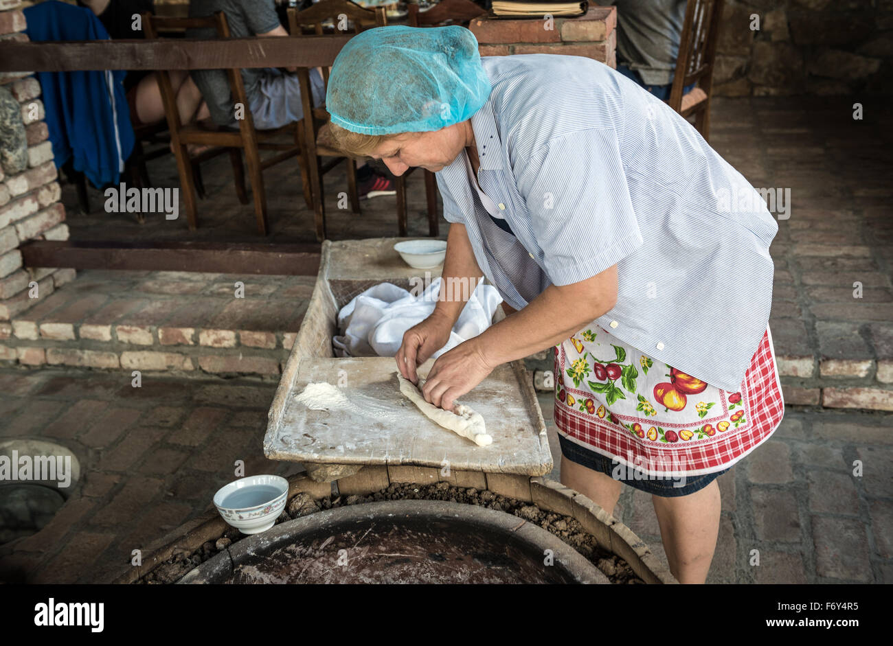 Woman shows traditional way of Shoti Bread baking in oven called tone (torne or turne) in Twins Wine Cellar, Napareuli, Georgia Stock Photo