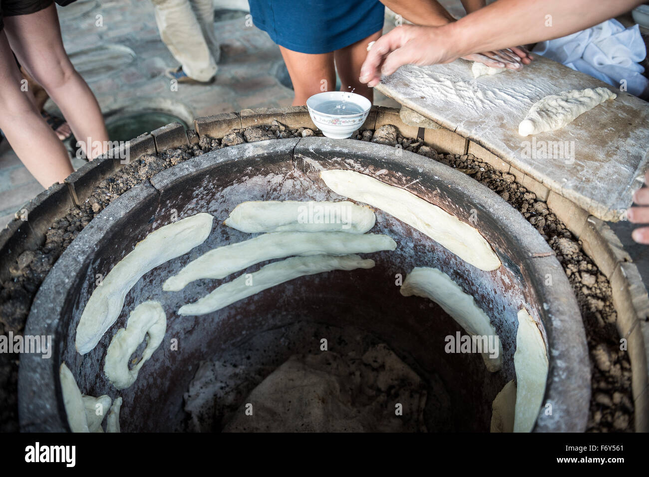 Woman shows traditional way of Shoti Bread baking in oven called tone (torne or turne) in Twins Wine Cellar, Napareuli, Georgia Stock Photo