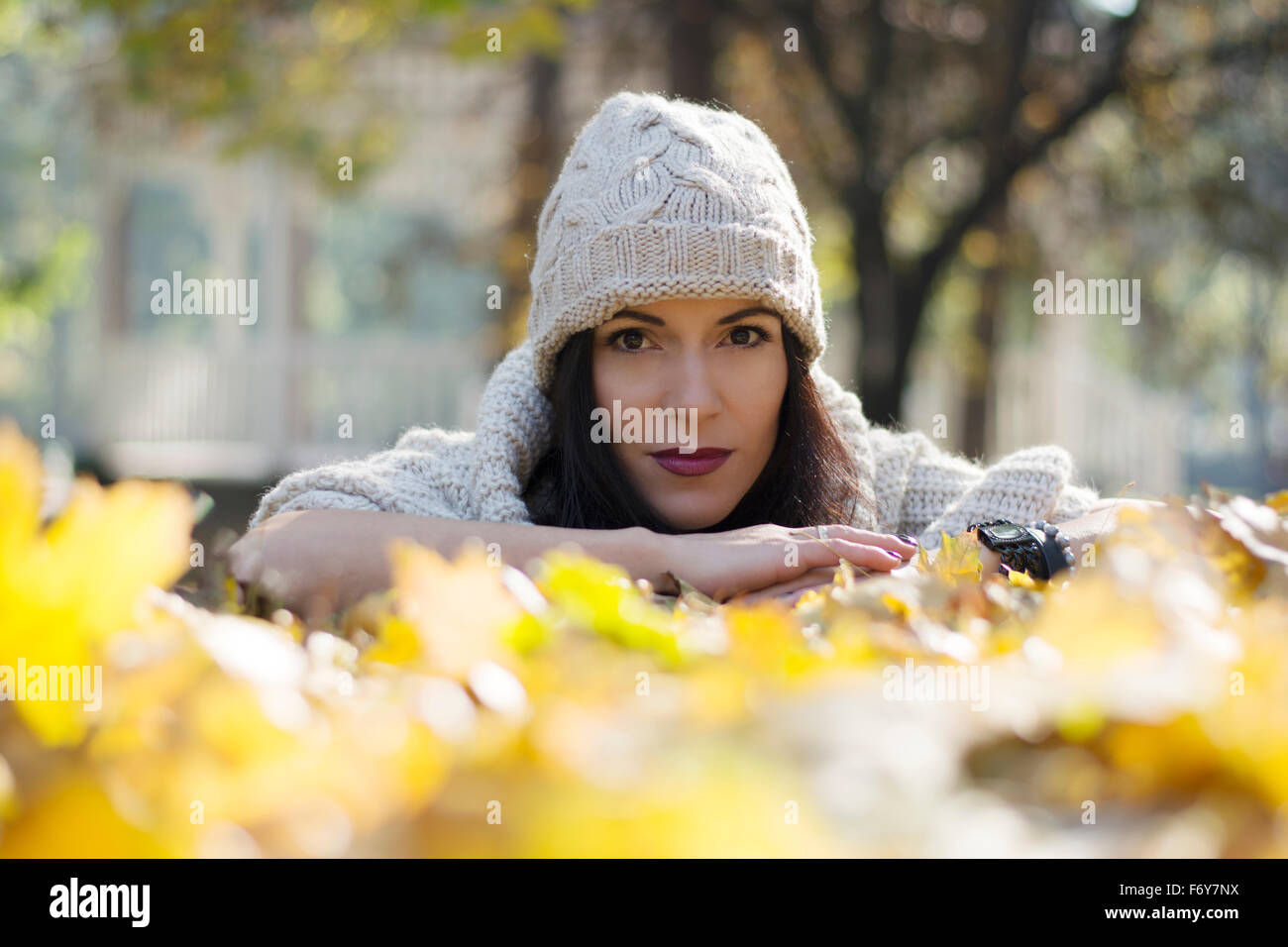 Beautiful and attractive black haired woman posing for a fashion shoot in park in fall Stock Photo