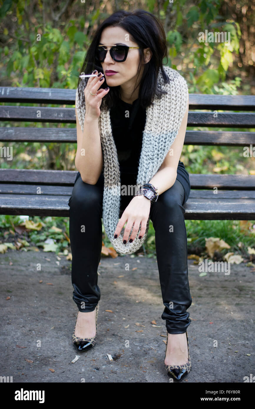 Attractive black hair woman enjoying smoking cigarette in park Stock ...