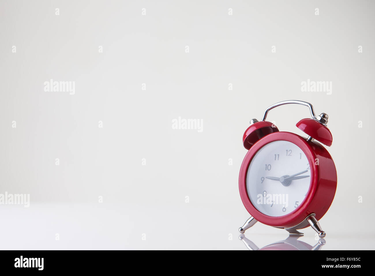 small classic style alarm clock on white background Stock Photo - Alamy