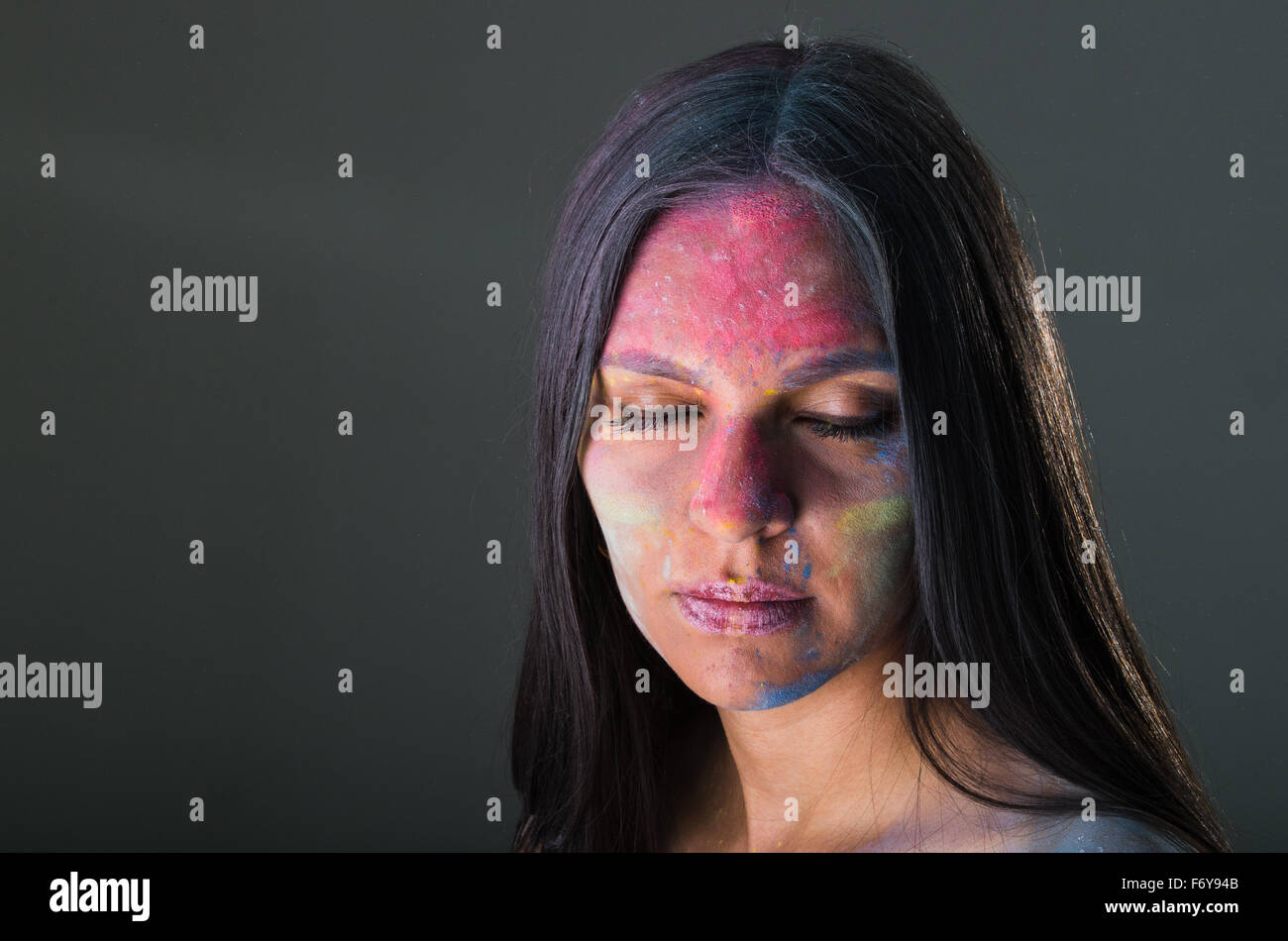 Beautiful young latin girl with colored powder on her face Stock Photo ...