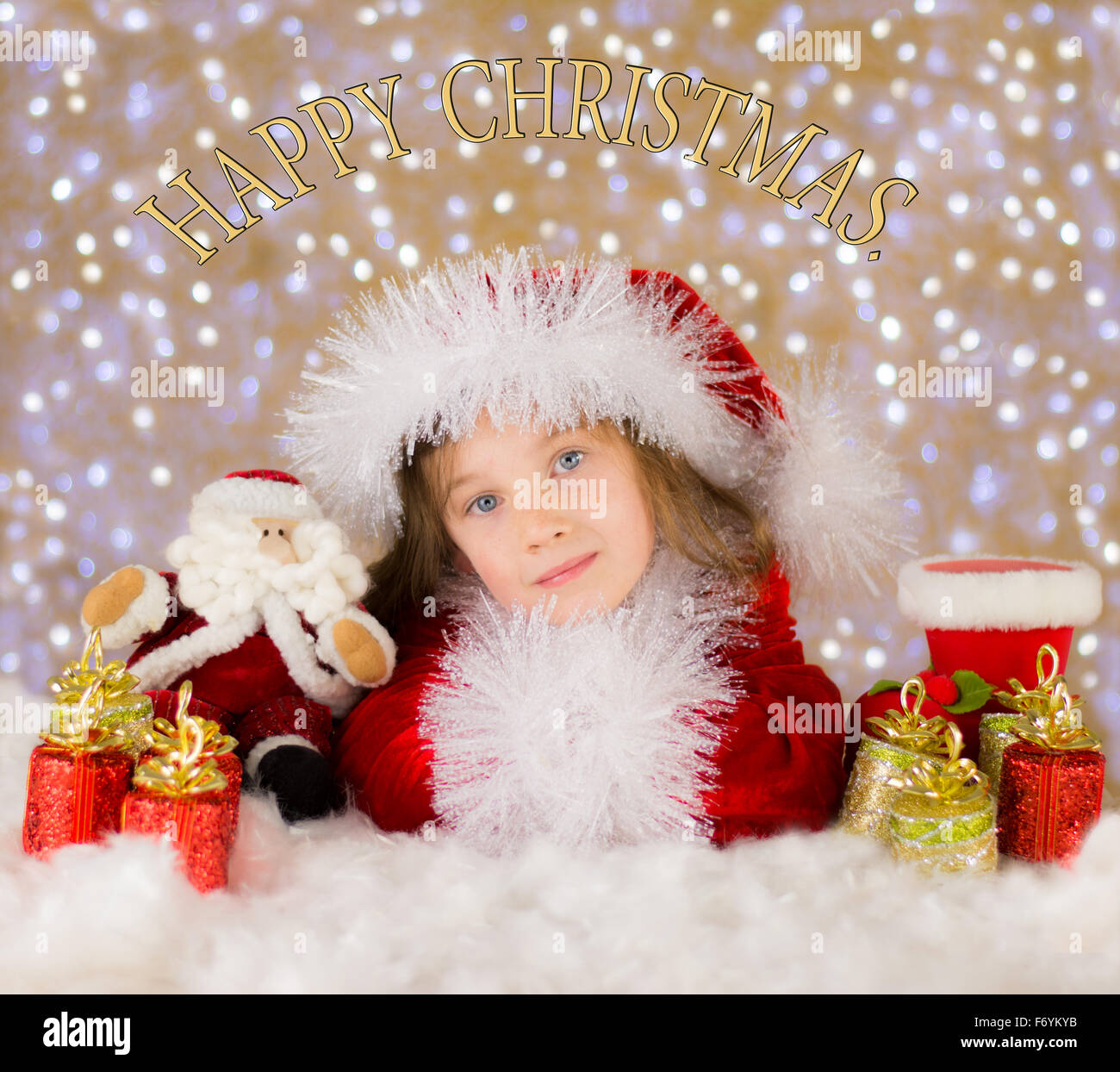 Happy pretty child in a Christmas scene with a bokeh background, in the style of a greeting card  with a Happy Christmas message Stock Photo