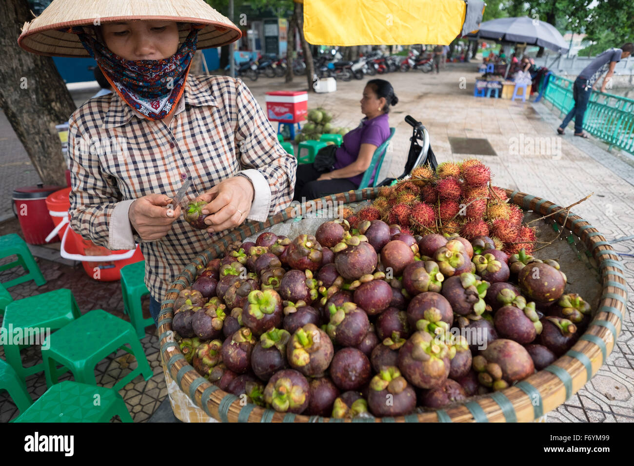 Fruit vendor in Hanoi, Vietnam selling mangosteen and rambutan Stock Photo