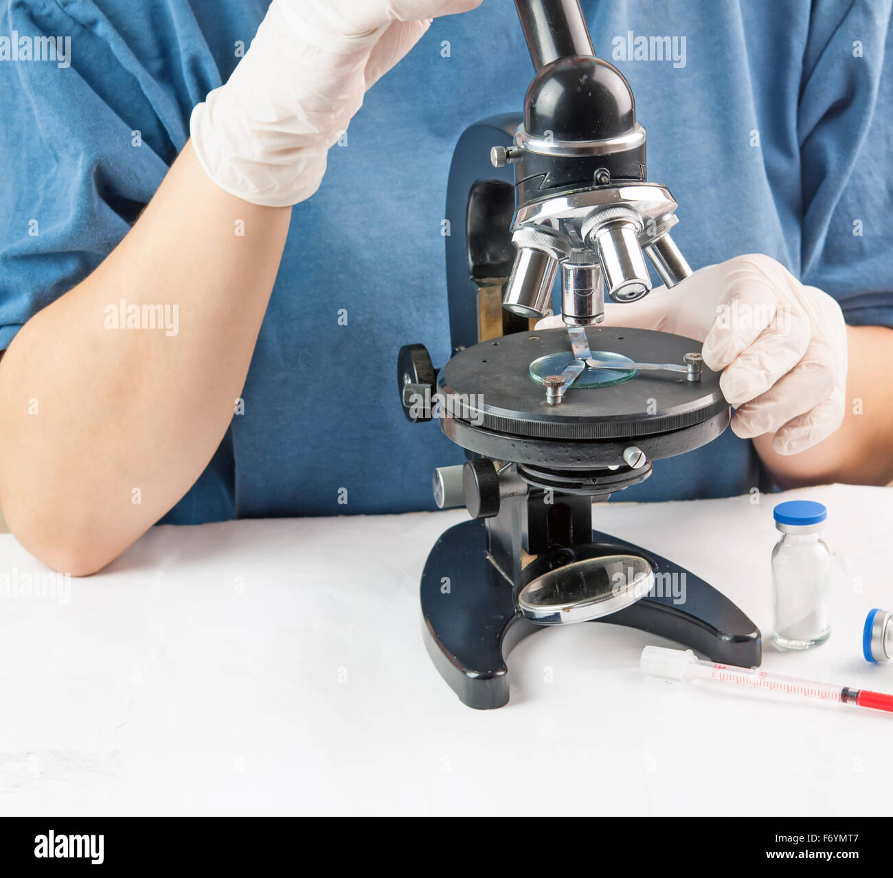 Attractive female scientist looking at the microscope slide in