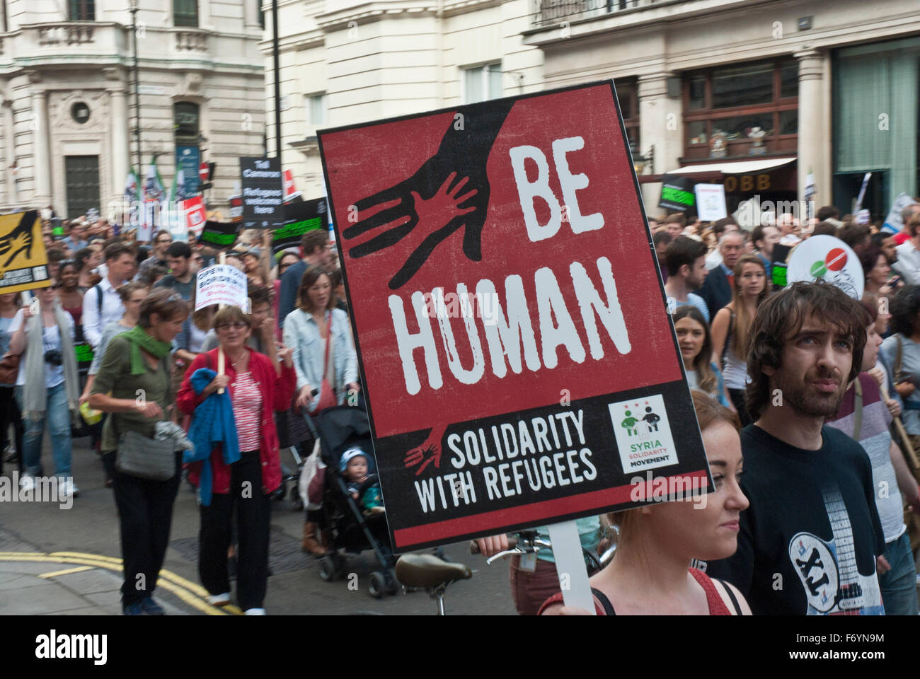 'Refugees welcome here' demonstration. Poster 'Be Human, solidarity with refugees' Stock Photo