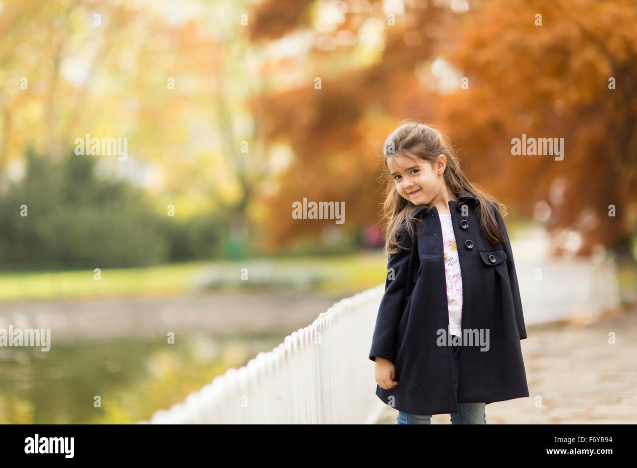 Little girl in the autumn park Stock Photo - Alamy