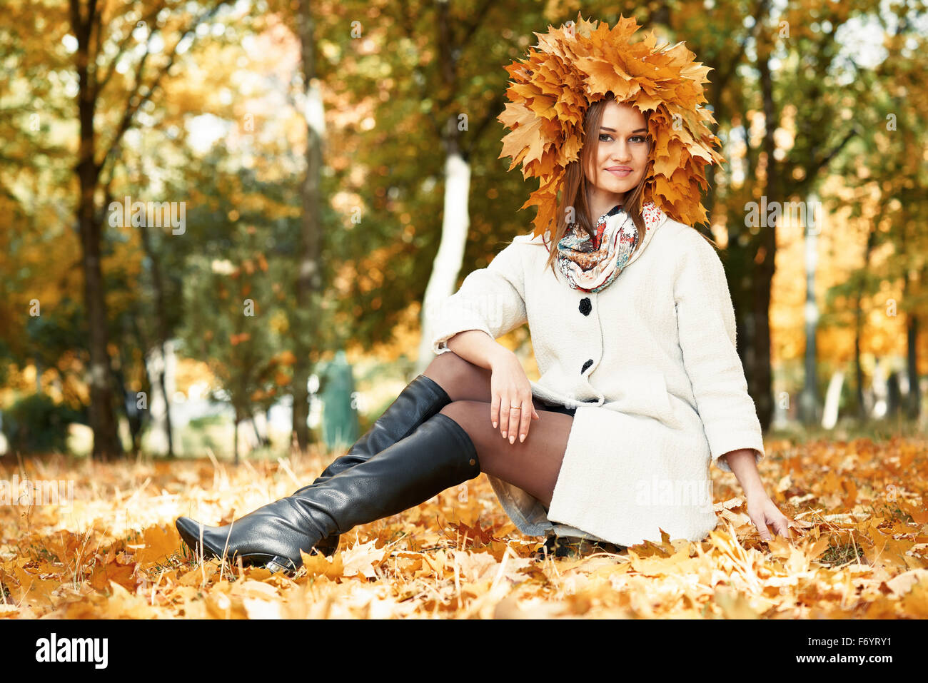 girl sitting on leaves in sunny autumn city park Stock Photo - Alamy