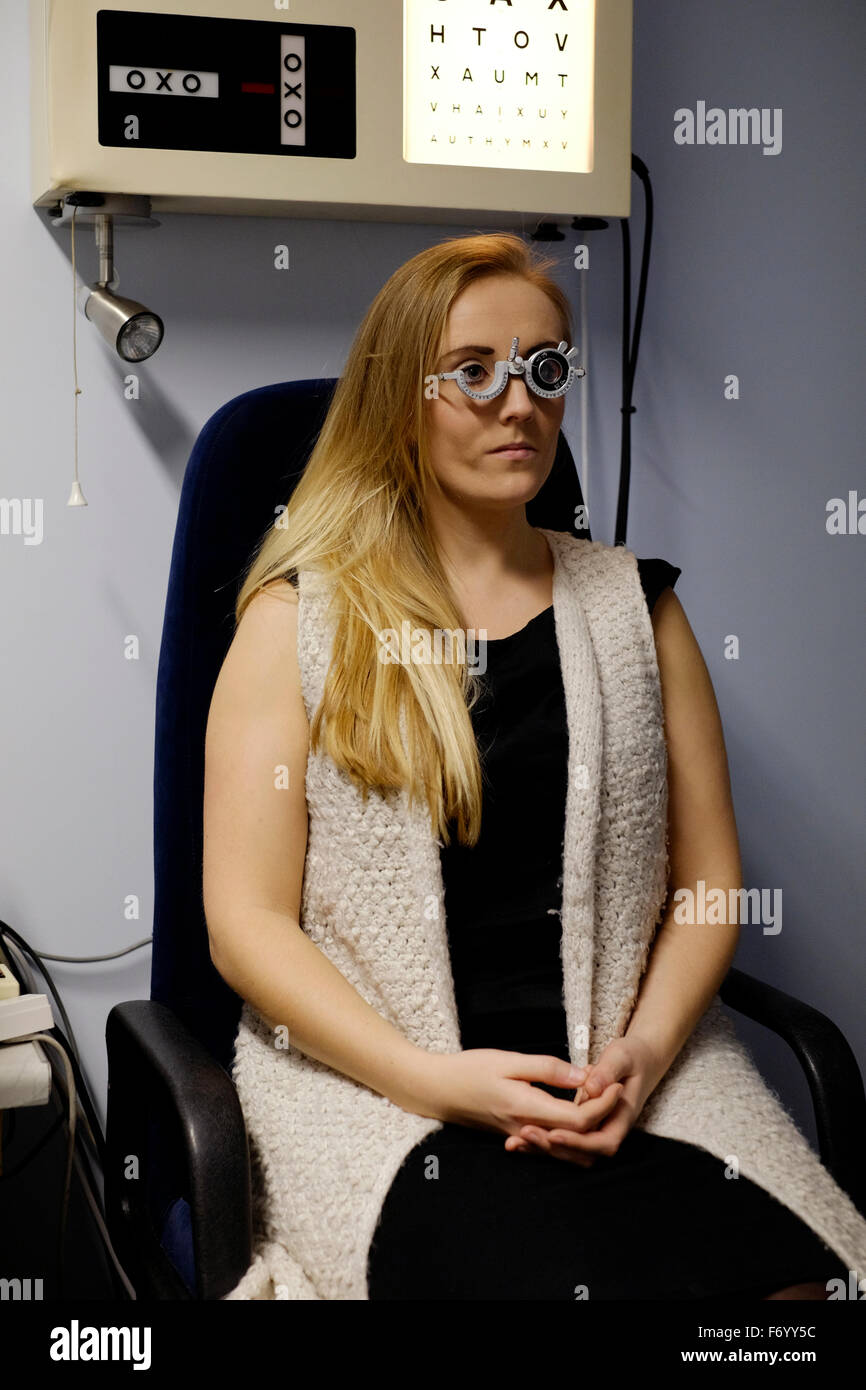 young woman receiving eye care at an opticians store in england uk Stock Photo