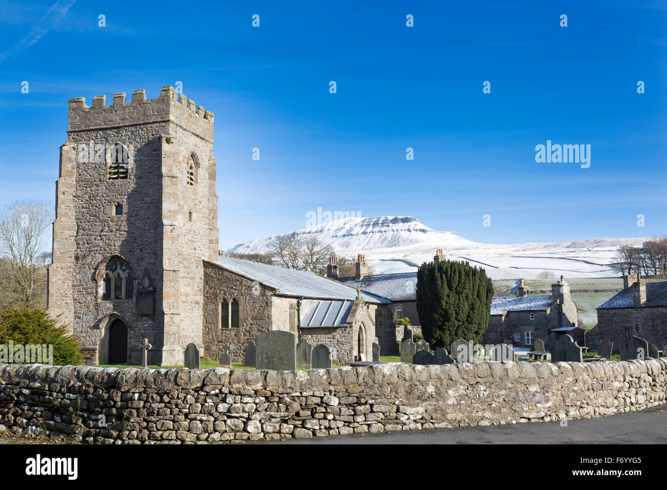 Horton in Ribblesdale church (St Oswalds), with a snow covered Pen-y-ghent mountain in the background Stock Photo