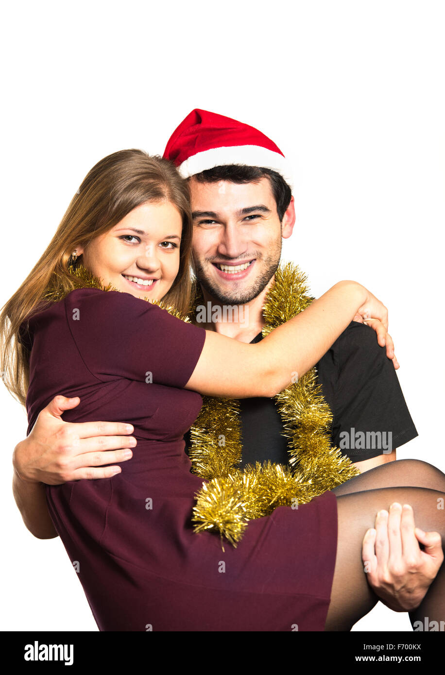 young couple, man and woman, smiling, happy, wearing Christmas decoration, man is carring woman Stock Photo