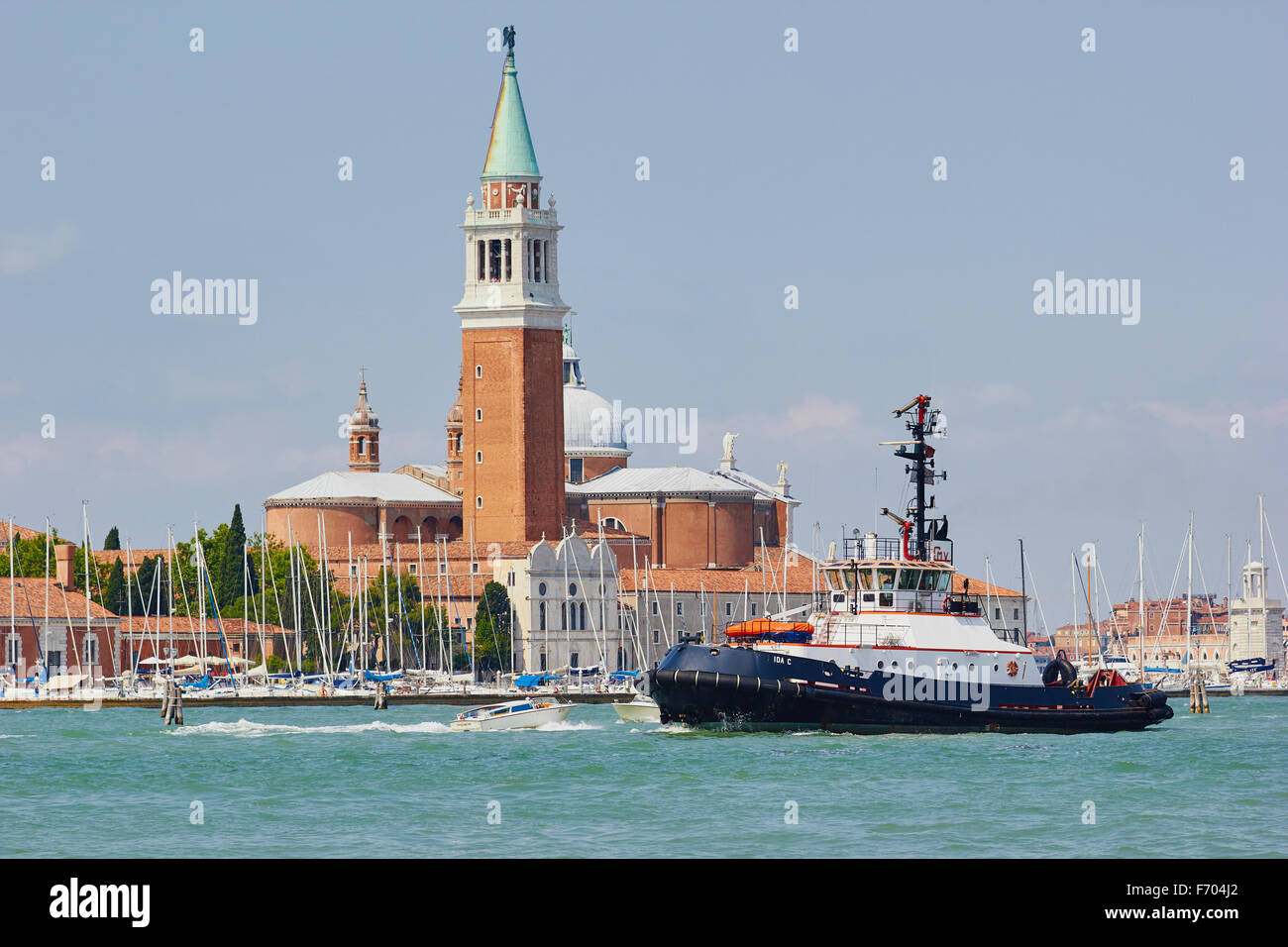 Tug boat passing San Giorgio Di Maggiore Basilica island and harbour Venice Veneto Italy Europe Stock Photo