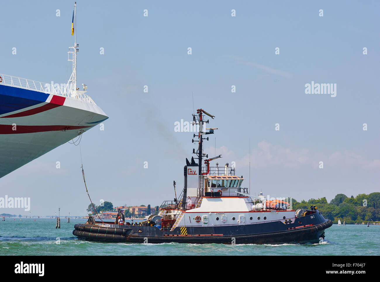Tugboat guiding a cruise liner into the San Marco canal Venice Veneto Italy Europe Stock Photo
