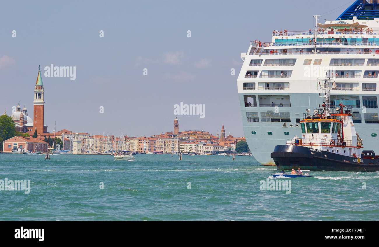 Tugboat leading a giant cruise liner down the San Marco canal Venice Veneto Italy Europe Stock Photo