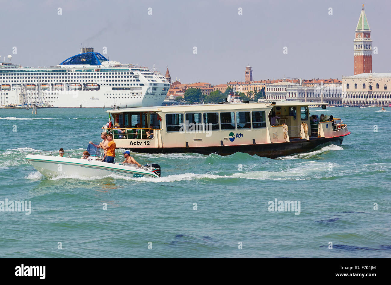 Giant cruise liner crossing the Venetian Lagoon with vaporetto waterbus in the foreground Venice Veneto Italy Europe Stock Photo
