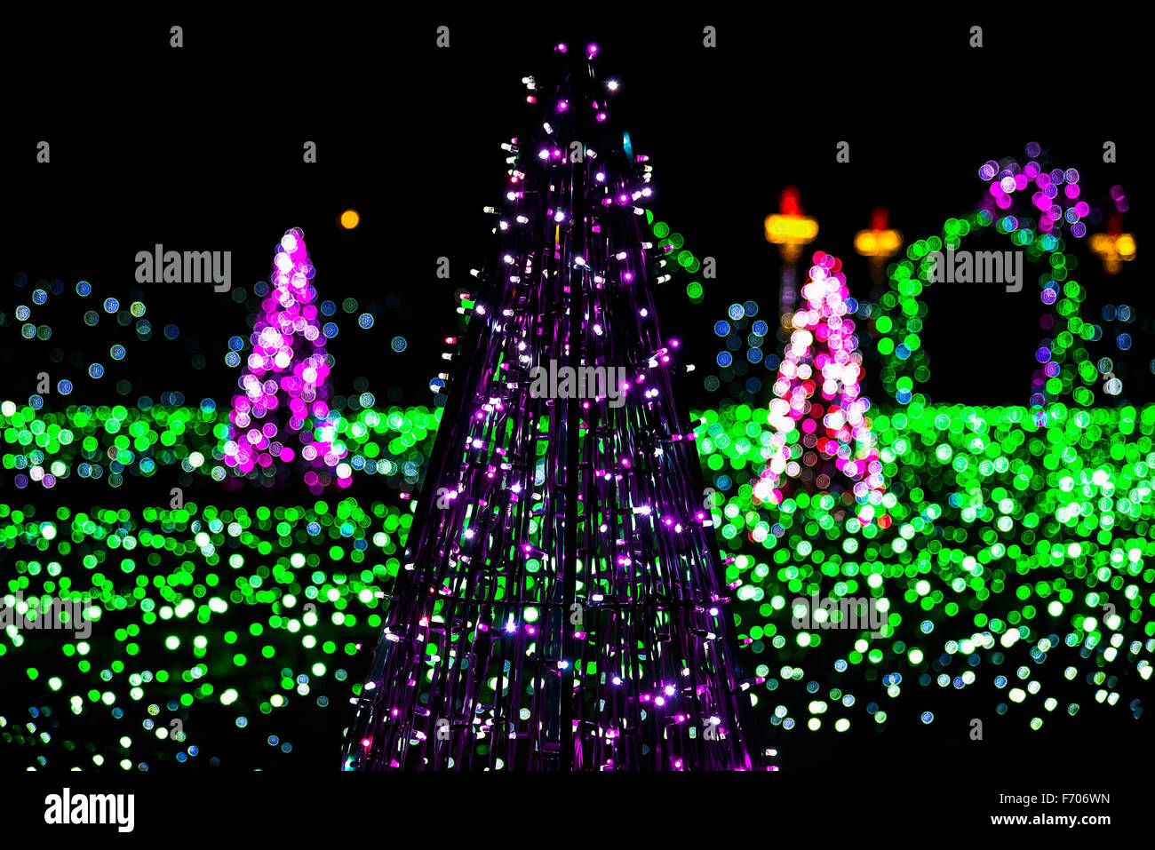 Christmas Tree made from Garlands with Colorful Lights in Background Stock Photo