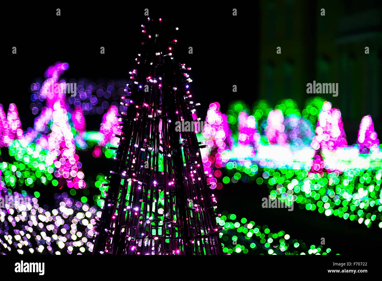 Christmas Tree made from Christmas Lighting Garland on Colorful Lights in Background at Building Stock Photo