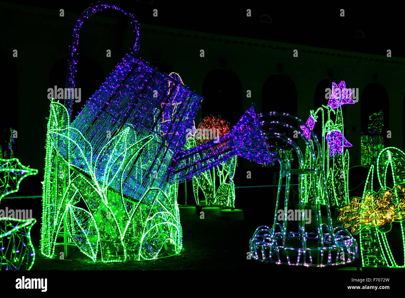Construction of Watering Can Illuminated from Colorful Lamps in Garden of Lights Stock Photo