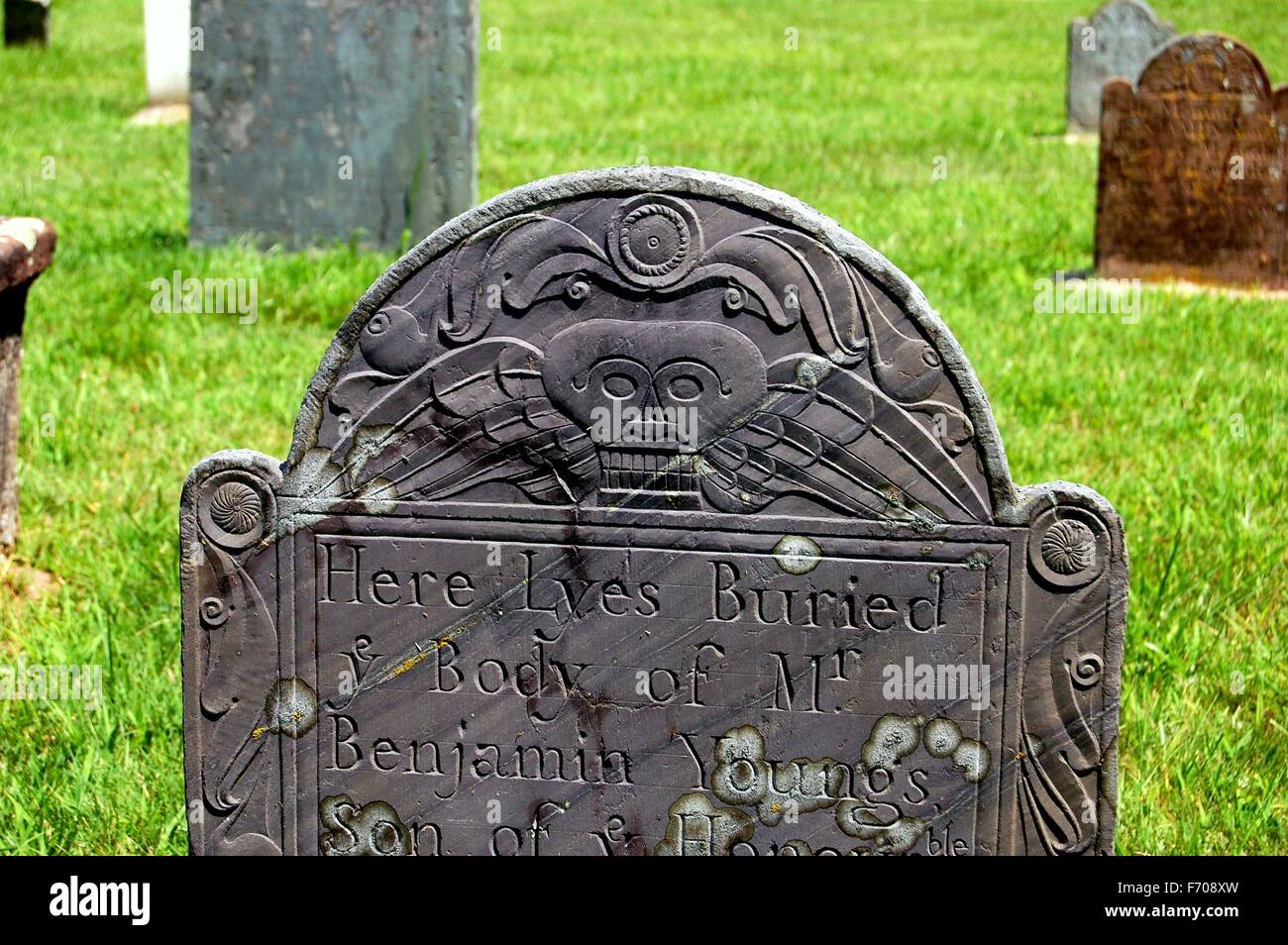 Southold / Long Island, New York:  Colonial-era tombstone with winged skeleton face in the graveyard Stock Photo