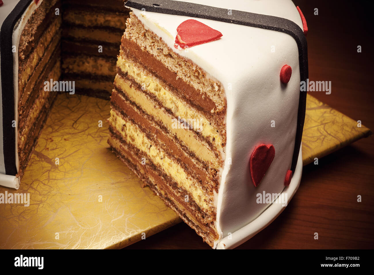 Anniversary cake decoration with red hearts and black ribbons. Stock Photo