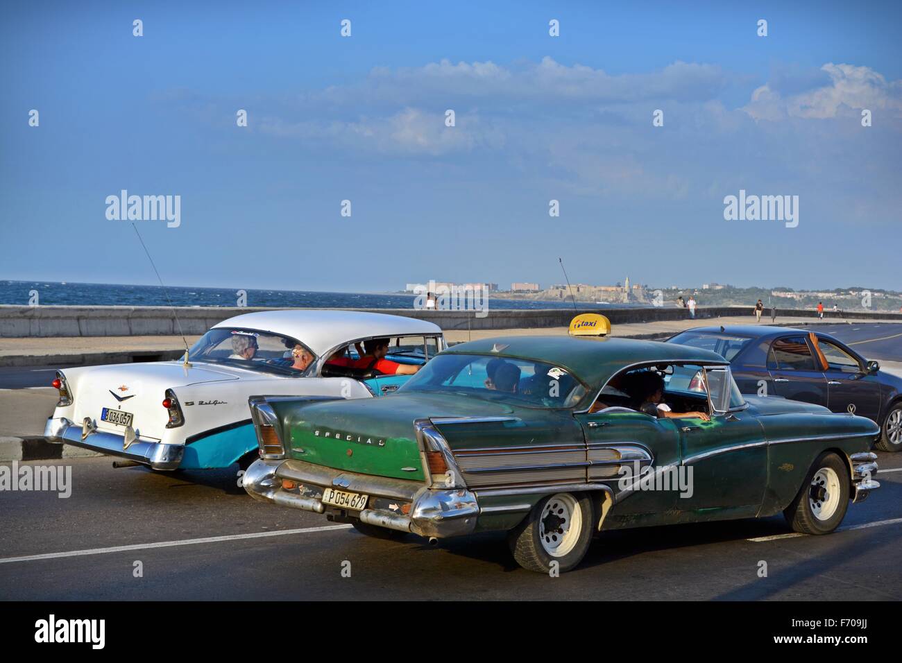 old American classic cars driving down the Malecon towards downtown Havana in Cuba Stock Photo