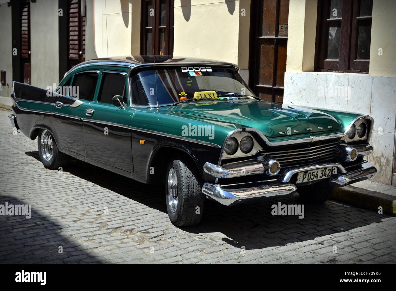 shiny metallic green and black vintage dodge taxi with tail fins parked on a sunny cobbled street in Trinidad Cuba Stock Photo