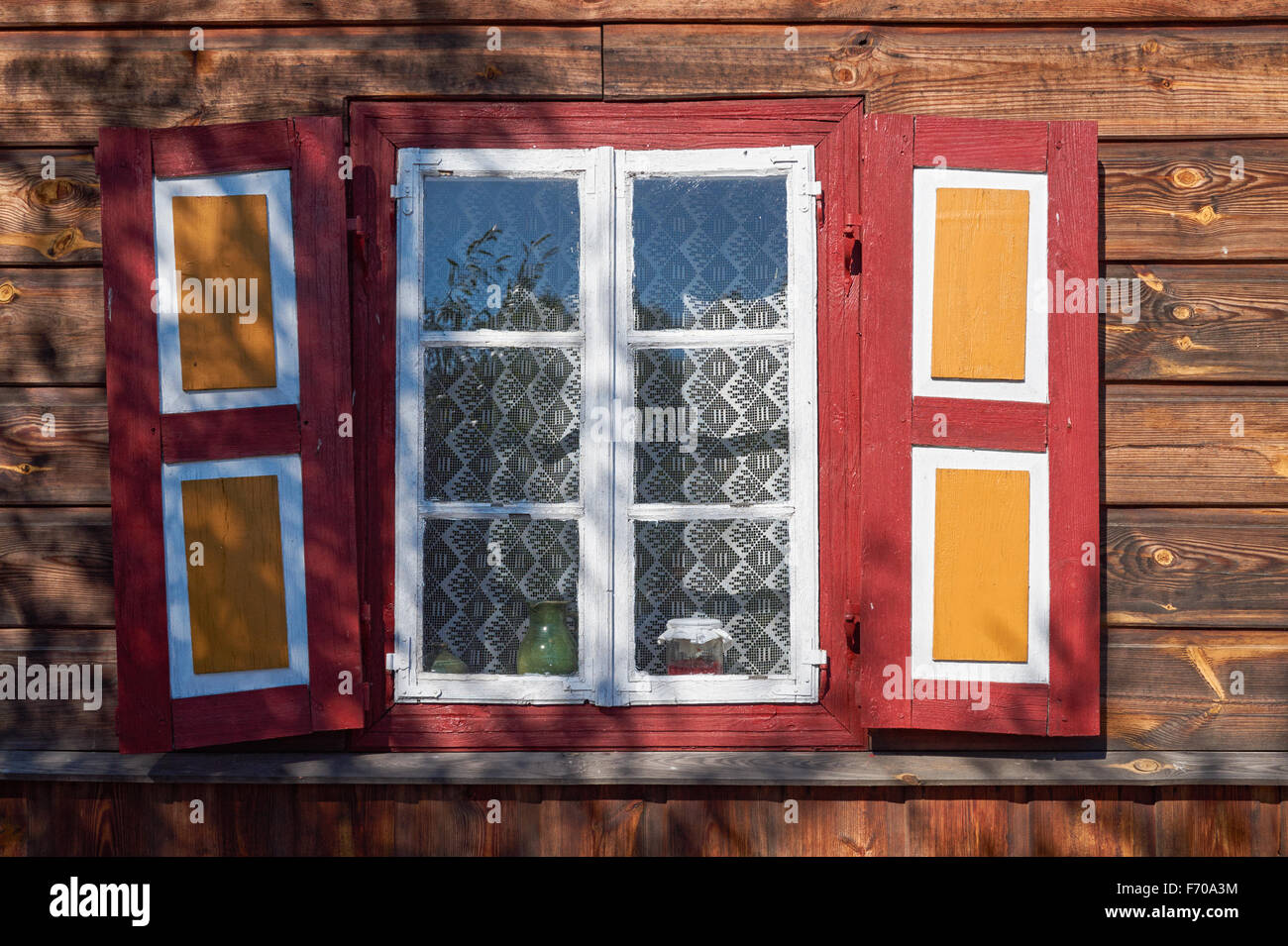 The Museum of the Mazovian Countryside in Sierpc, Poland. Old wooden peasant thatched farmhouse with decorative shutters. Stock Photo