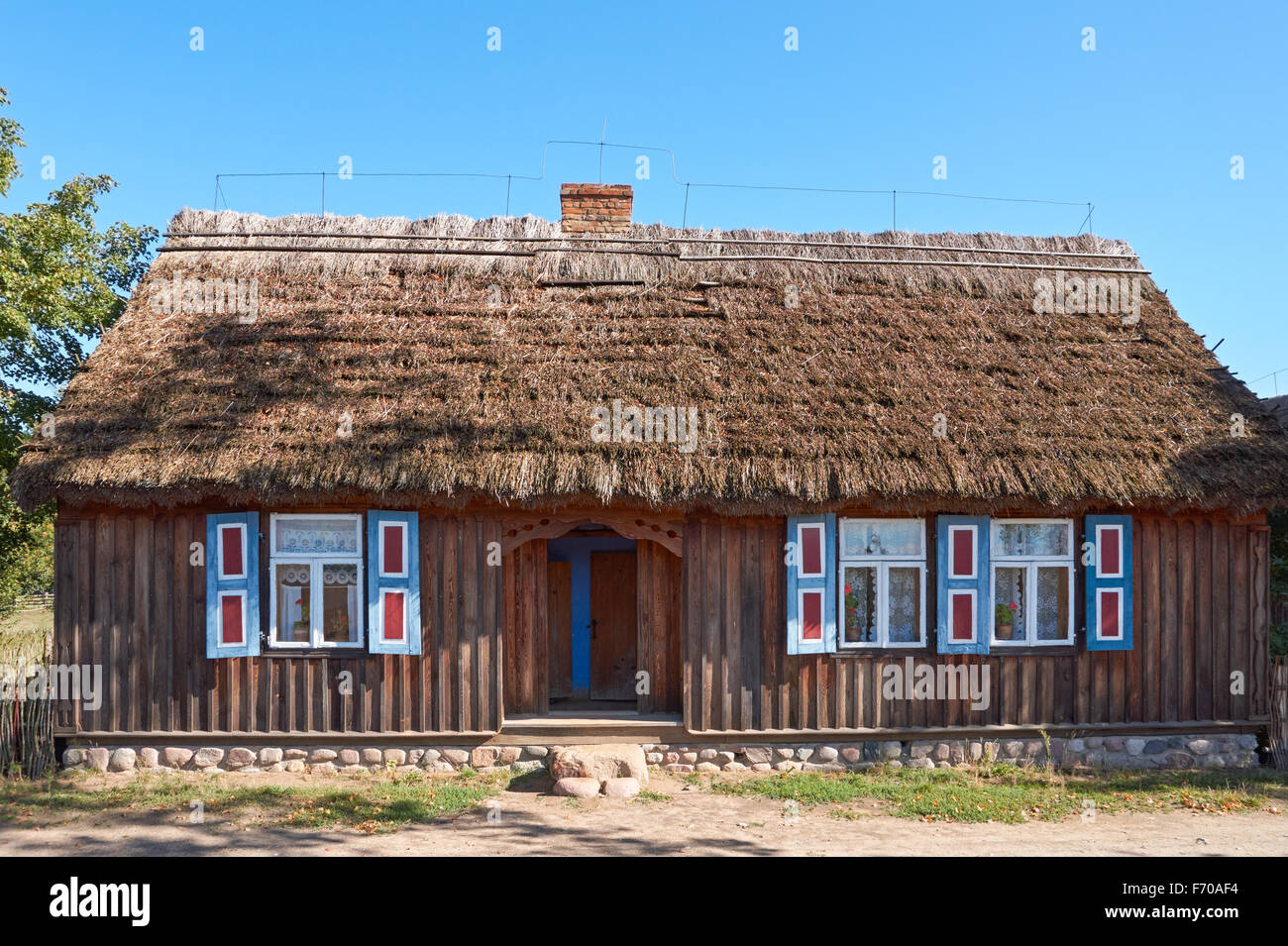 The Museum of the Mazovian Countryside in Sierpc, Poland. Old wooden peasant farmhouse with thatched roof. Stock Photo