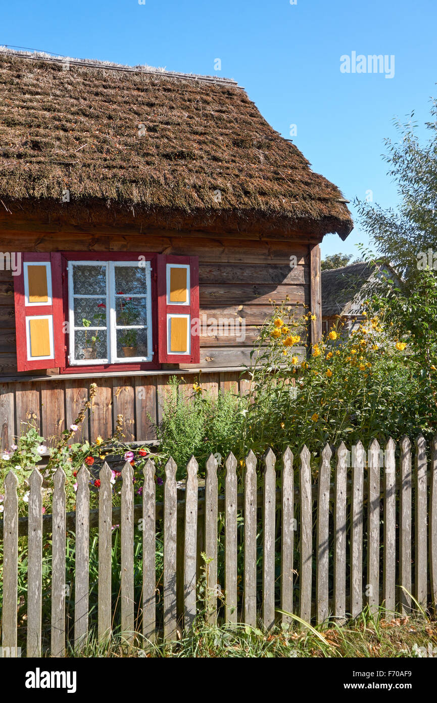 The Museum of the Mazovian Countryside in Sierpc, Poland. Old wooden peasant thatched farmhouse with decorative shutters. Stock Photo