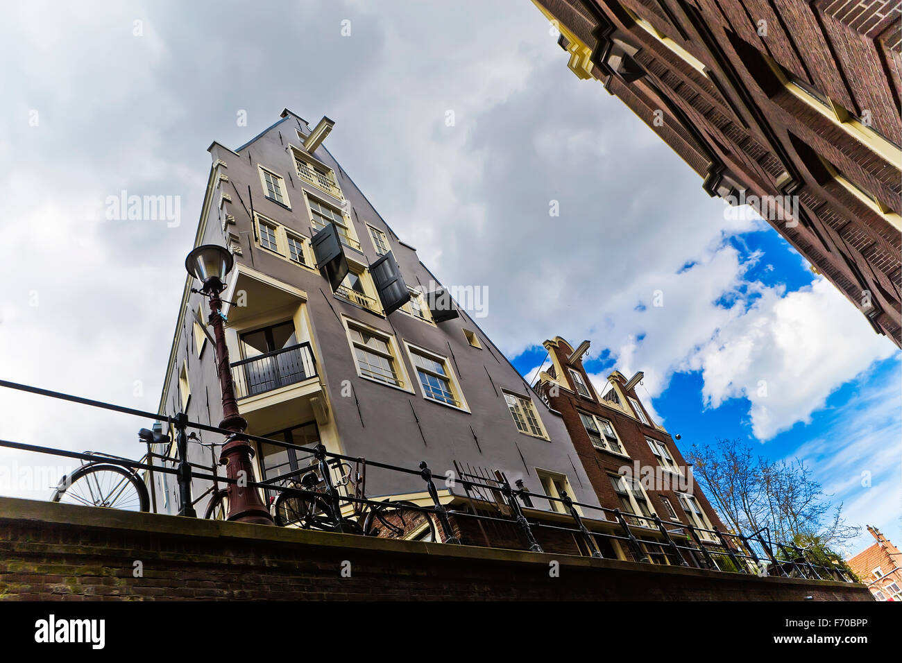 Image of a canal side house situated on a Amsterdam canal and showing the window storm shutters open at the  front of the house Stock Photo