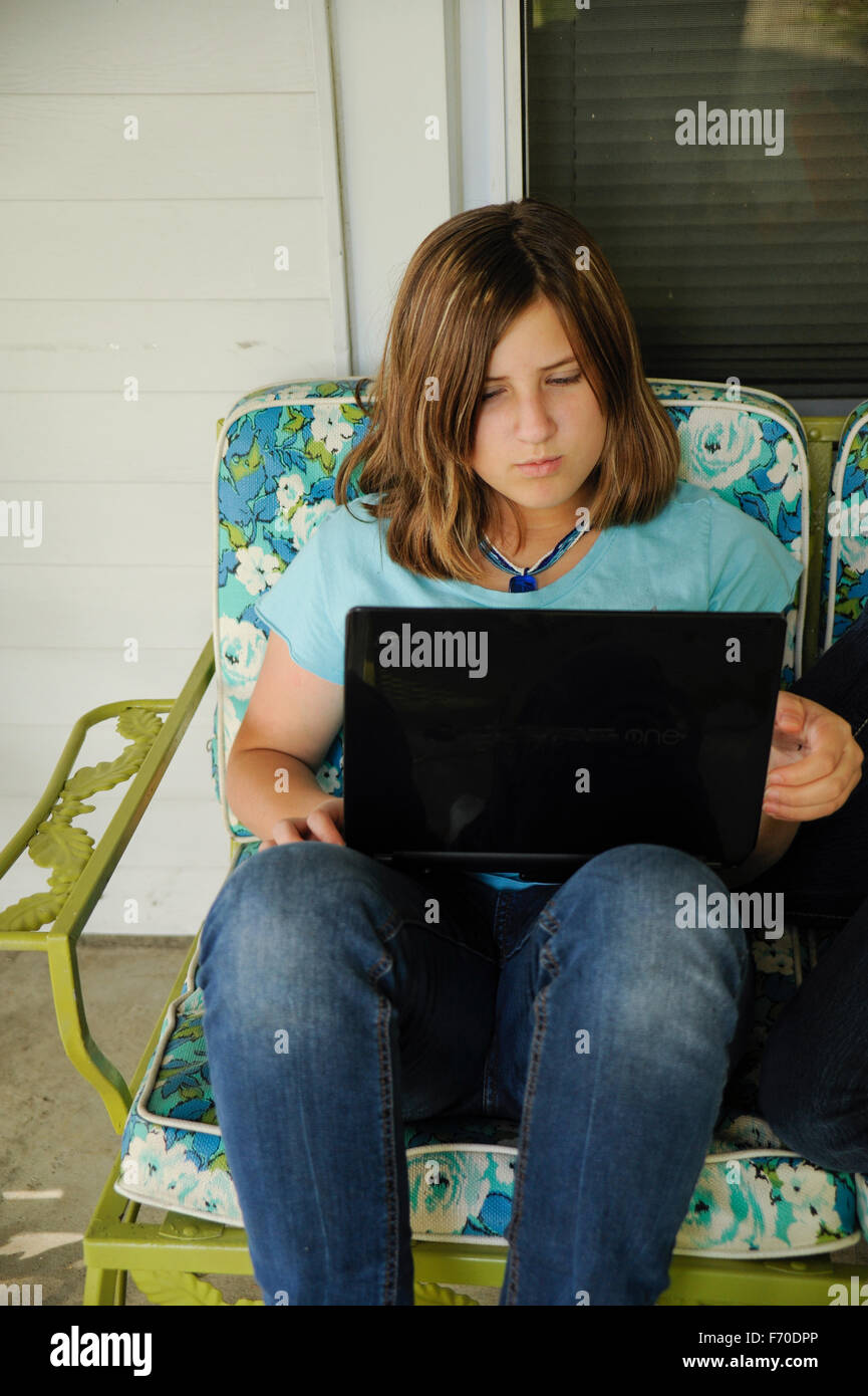 Teen Mexican girl using laptop to plan a school art lesson. Stock Photo