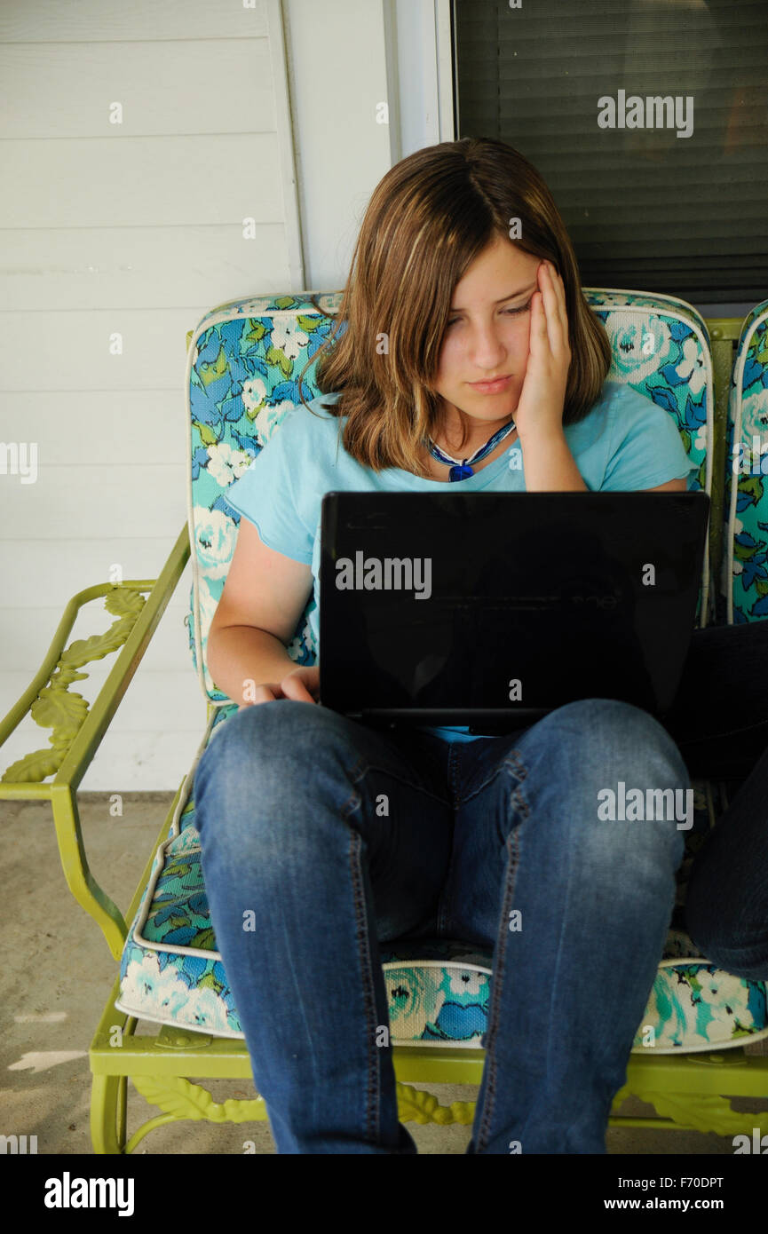 Teen Mexican girl using laptop to plan a school art lesson. Stock Photo