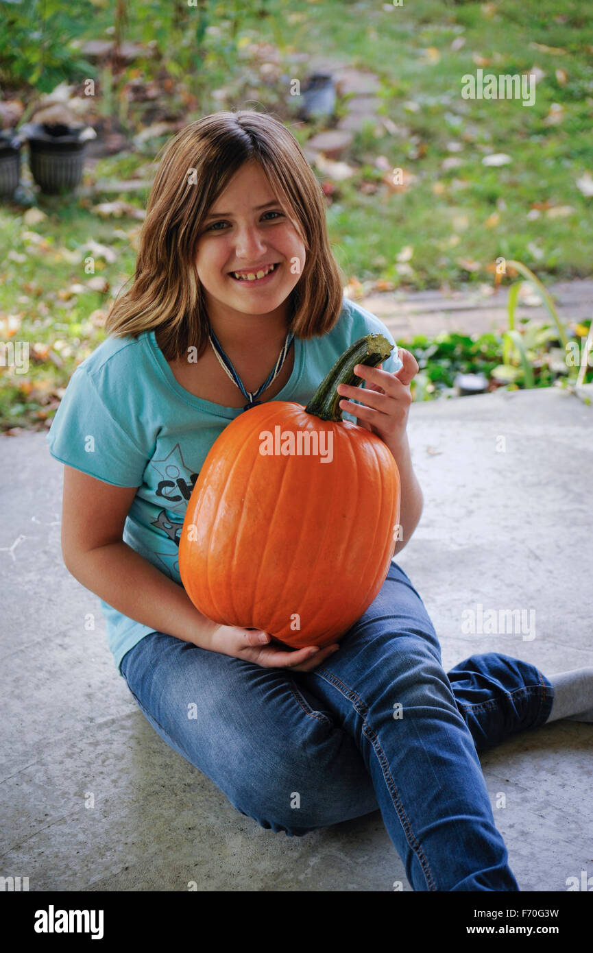 Pre-teen girl holding pumpkin, Indiana Stock Photo