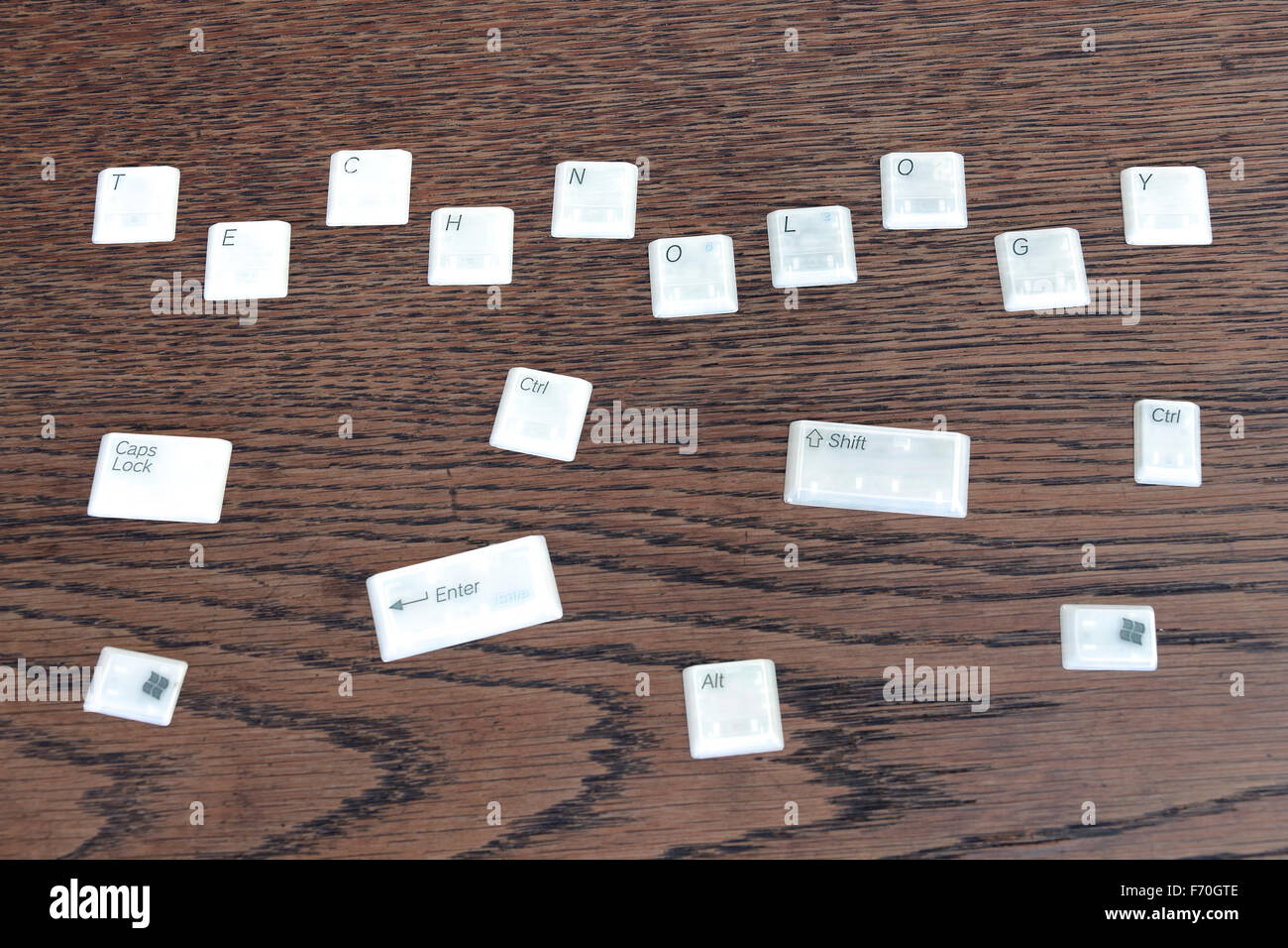 Different computer keys lying on a wooden table, word technology. Stock Photo