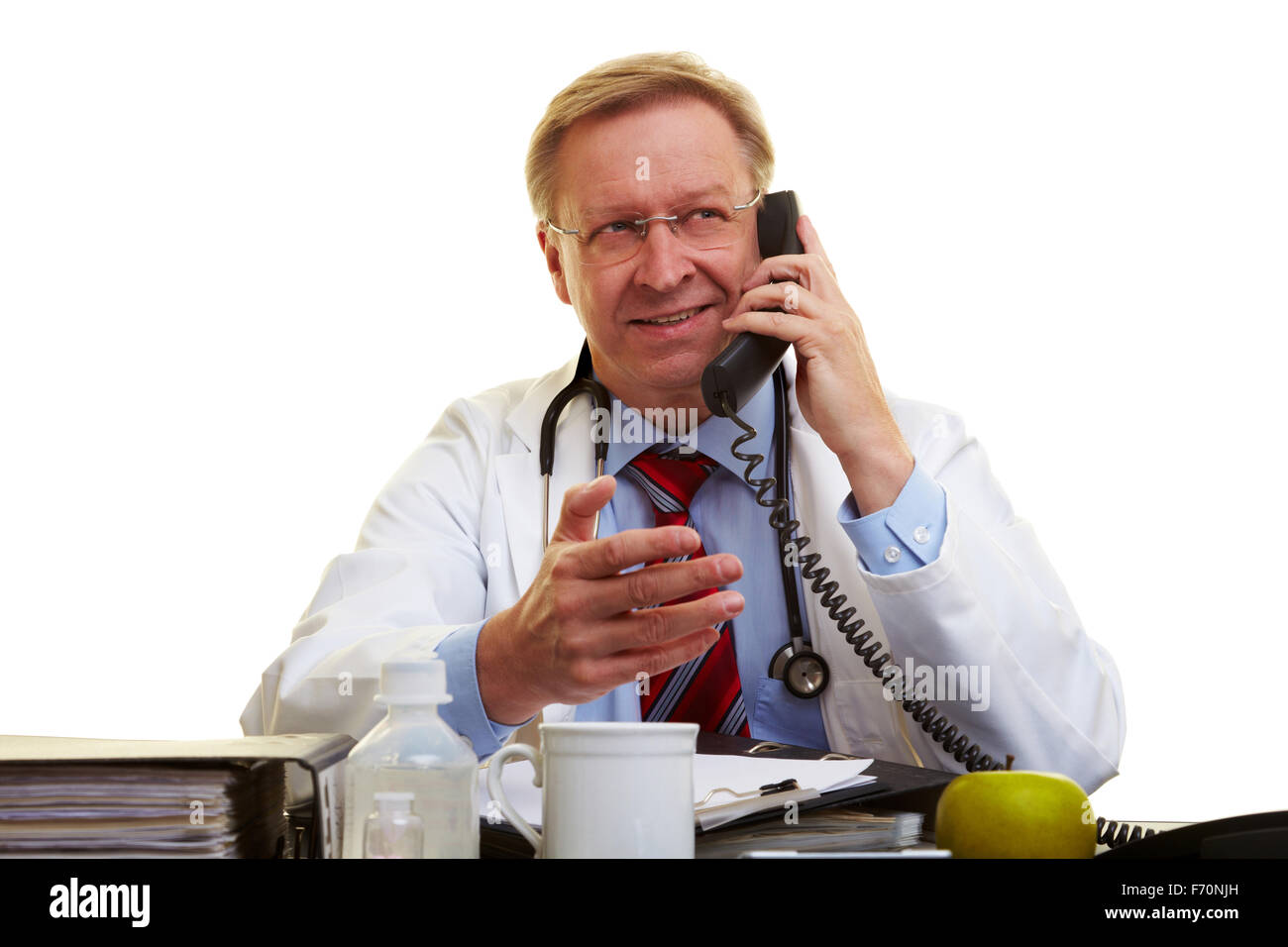 Physician sitting at a desk and talking on the phone Stock Photo