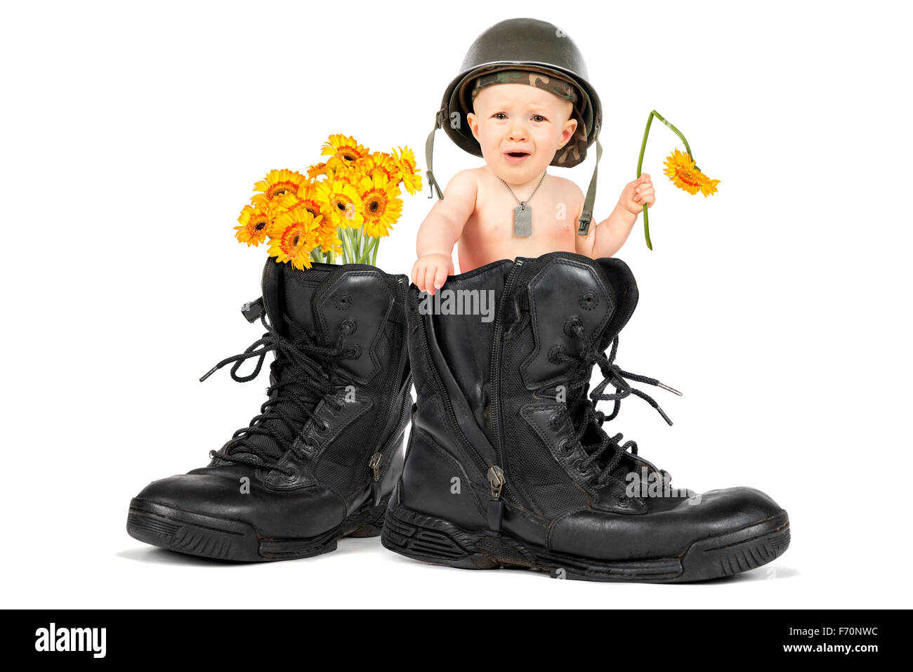 Cute baby girl soldier with flower inside a military boot Stock Photo
