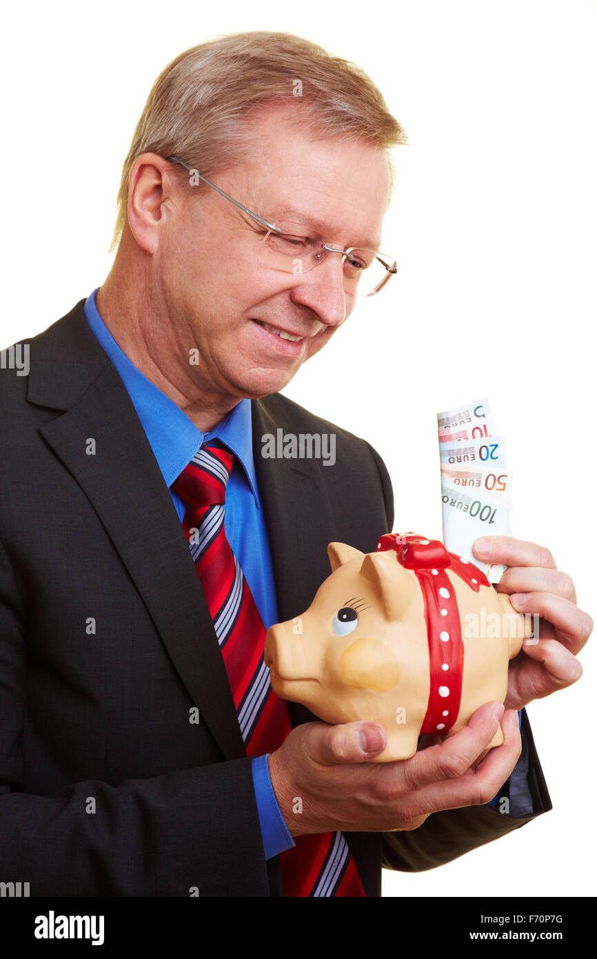 Smiling senior businessman holding piggy bank and banknotes Stock Photo ...