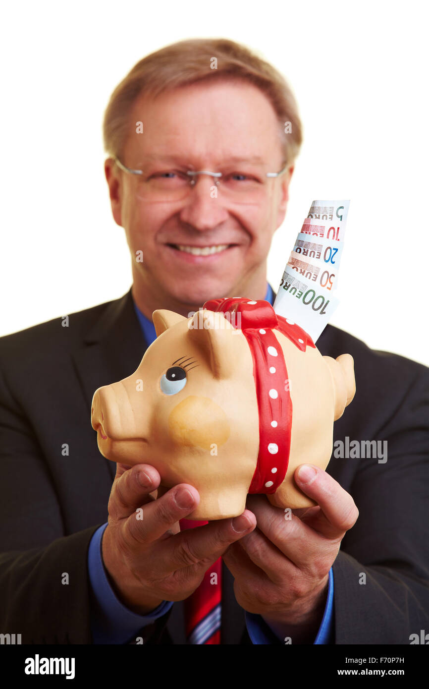 Smiling senior businessman holding piggy bank and banknotes Stock Photo ...