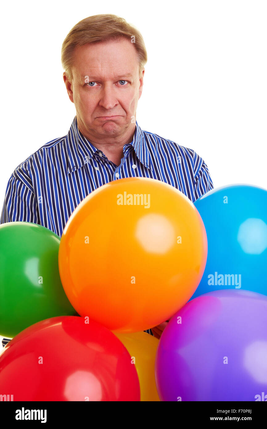 Sad elderly man holding many colorful balloons Stock Photo