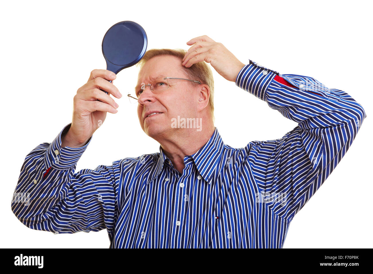 Eldery man watching his receding hair line in mirror Stock Photo