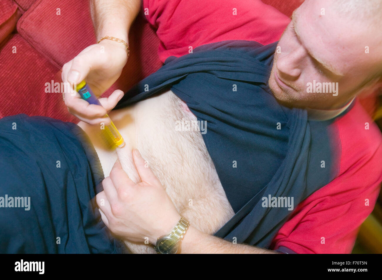 Man with Diabetes injecting insulin into his stomach, Stock Photo