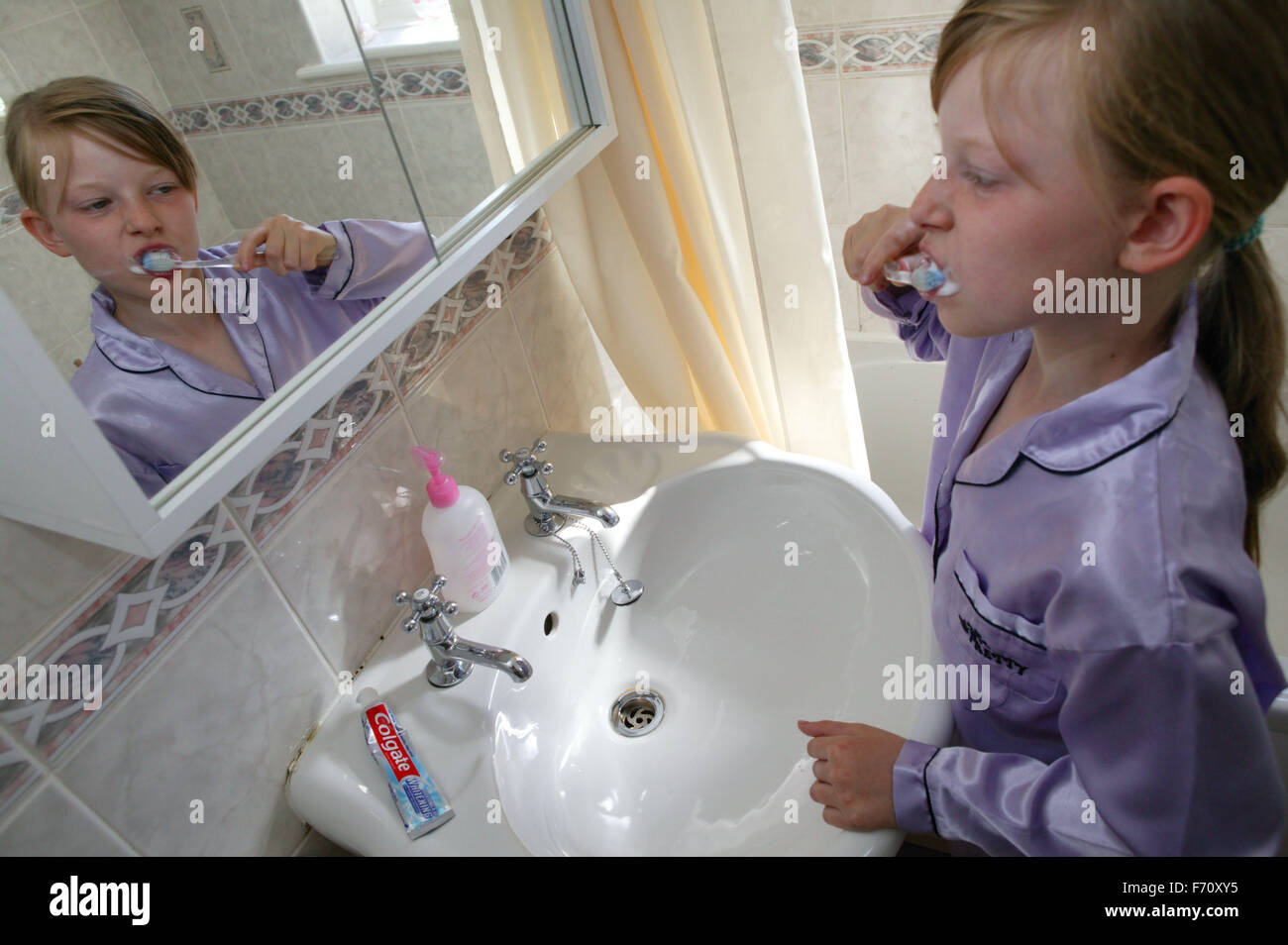 Girl in her pyjamas brushing her teeth, Stock Photo