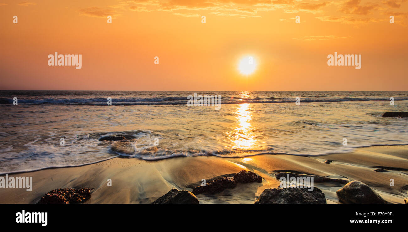Waves on beach at sunset hi-res stock photography and images - Alamy