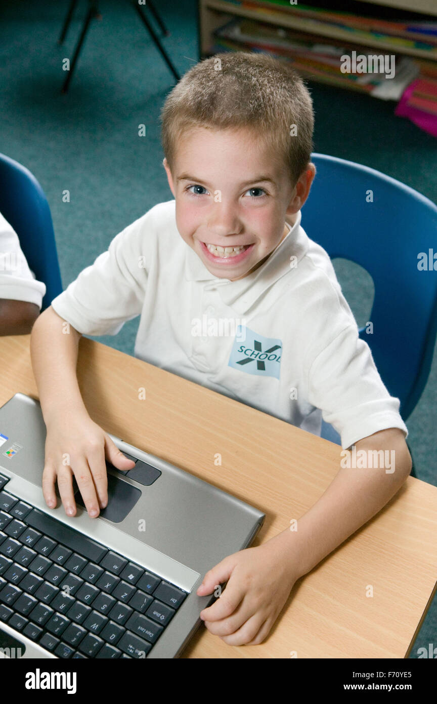 School boy using computer in classroom smiling Stock Photo Alamy