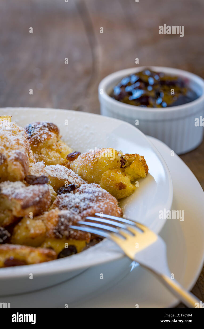 Kaiserschmarrn, traditional austrian cut-up and sugared pancake with raisins on a white plate Stock Photo