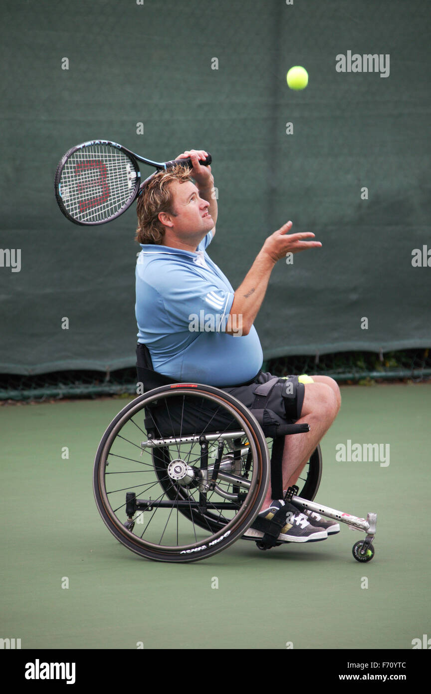 Disabled man playing wheelchair tennis in an adapted wheelchair at the