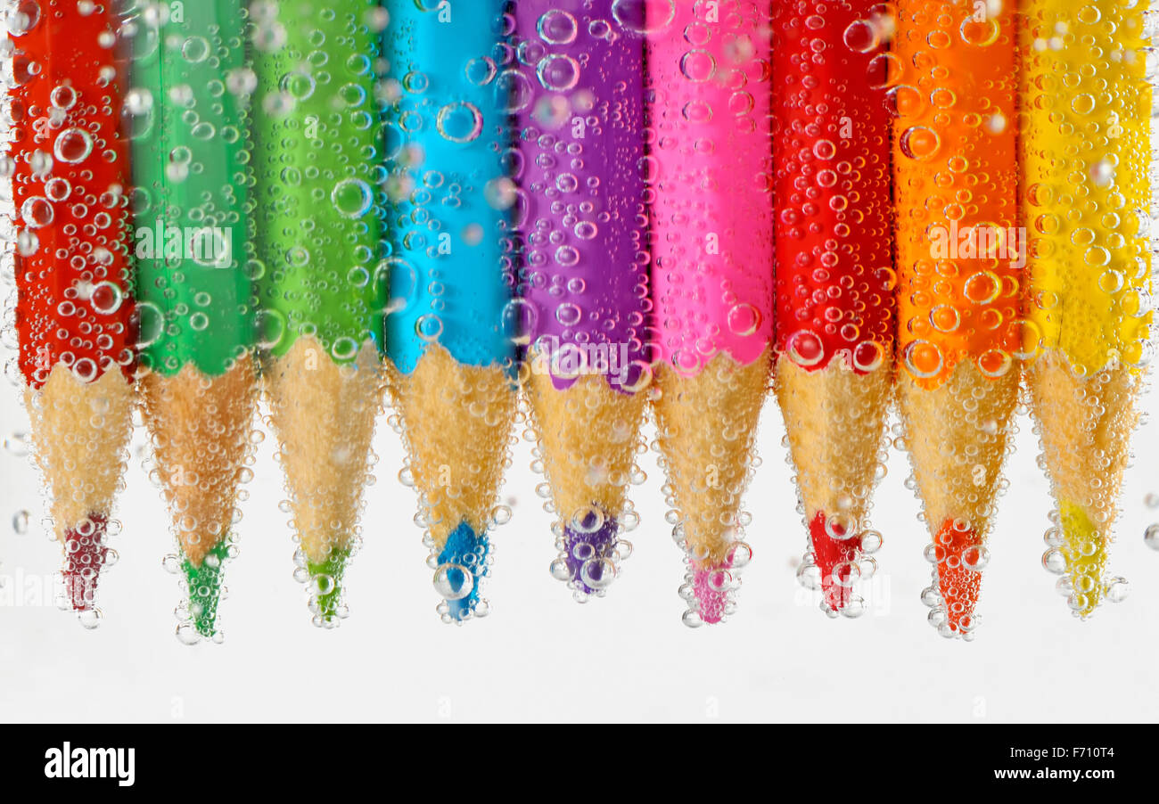 Pencils in water with bubbles Stock Photo